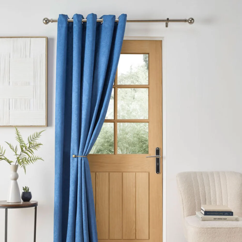 Blue curtain draped beside glass door in bright hallway
