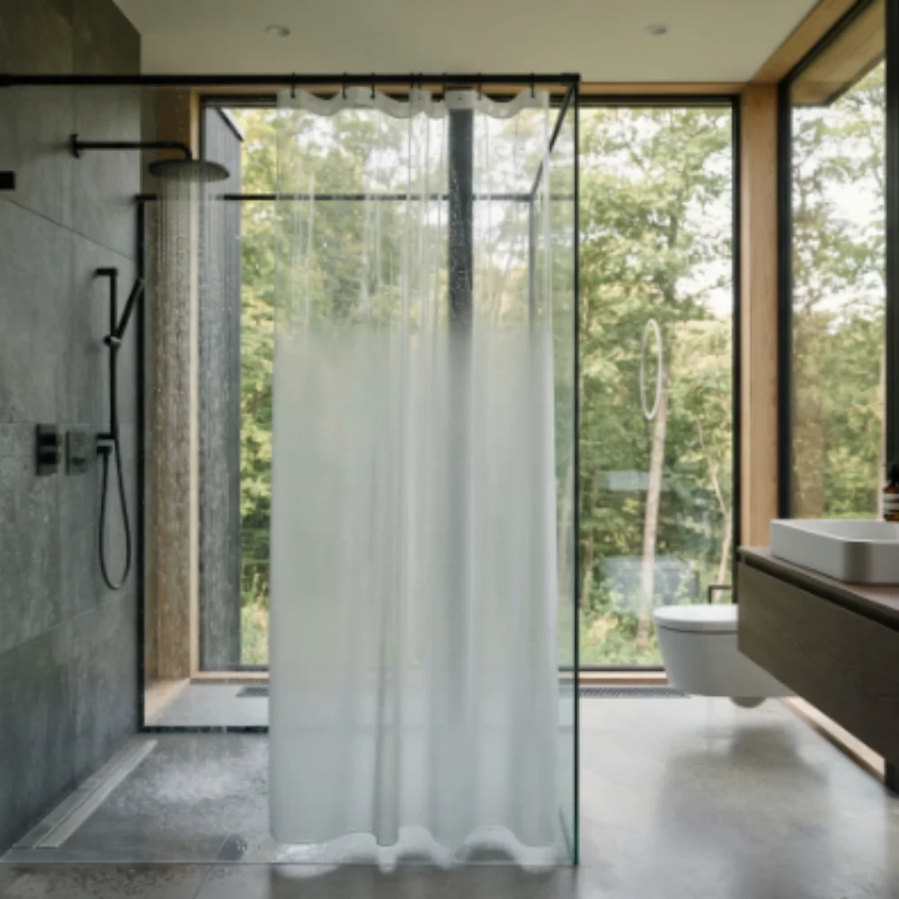 Sheer shower curtain in luxury glass walled bathroom